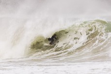 A surfer gets barreled as an offshore wind feathers a frothy wave at a remote Catlins' beach, Catlins, New Zealand. 