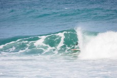 A surfer gets barreled in fun waves on the Otago Peninsula, Dunedin, New Zealand.