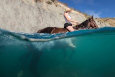 Izy swims Cleo in the Clarence River at Muzzle Station, Kaikoura, New Zealand.