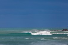 A surfer bottom turns during a once in a blue moon swell at a secret bank near Dunedin, New Zealand.