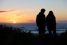 Janis and Eva watch the sunrise near Dunedin, New Zealand.