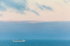A cruise ship heads from Dunedin to Milford Sound off shore from St Kilda, Dunedin, New Zealand.
