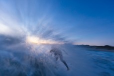 A surfer throws spray in punchy waves at St Kilda, Dunedin, New Zealand.