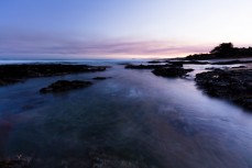 Rockpool surges at dusk near Brighton, Dunedin, New Zealand.