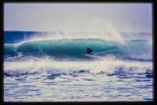 Brett Wood finding cover during surf exploration in the Far North, New Zealand. Derek Morrison Archives 1993-1996