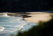 Beach walkers at Tomohawk Beach, Dunedin, New Zealand.