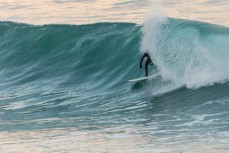 A surfer gets barreled in autumn waves at St Clair Beach, Dunedin, New Zealand.