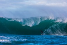 Tim Searing rides a giant wave at a remote reefbreak near Dunedin, New Zealand.