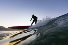 Keara Brownlie surfing at dawn near Brighton Beach, Dunedin, New Zealand.