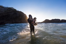 Tom Brownlie with his dogs at dawn near Brighton Beach, Dunedin, New Zealand.
