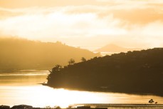 Fog rolling up the Otago Harbour in the early winter morning, Dunedin, New Zealand.