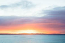 Dawn breaks over swell lines at Riverton Rocks, Southland, New Zealand.