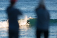 People watch the fun winter waves at Blackhead Beach, Dunedin, New Zealand.