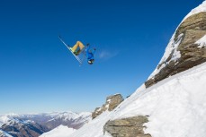 The North Face athlete Fraser McDougall backflips off a rock on a bluebird day at Treble Cone Ski Resort, Wanaka, Central Otago, New Zealand.