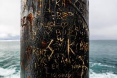 Grafitti on a signal pole on the end of the spit on the north coast at Aramoana, Dunedin, New Zealand.