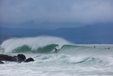 A surfer drops into a fun wave on the north coast at Aramoana, Dunedin, New Zealand.
