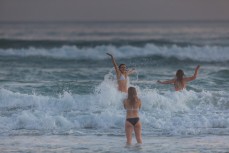 Varsity friends Brooke Monkley, Aimee Donaldson and Alyx Kingston enjoy a late afternoon swim at St Kilda, Dunedin, New Zealand.