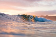 Sunset illuminates a summer ground swell at St KIlda, Dunedin, New Zealand.