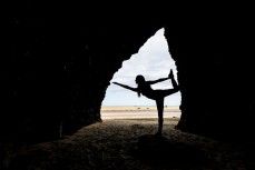 Ella Johnstone finds her balance in a cave at Bethells Beach, Auckland, New Zealand.