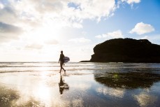 Odile Smits enjoys fun summer waves at Bethells Beach, Auckland, New Zealand.