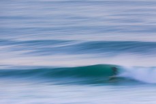 A surfer finds a nugget during a raw ground swell at St Kilda, Dunedin, New Zealand.