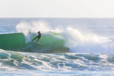 A surfer finds a nugget during a raw ground swell at St Kilda, Dunedin, New Zealand.