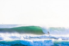 A surfer finds a nugget during a raw ground swell at St Kilda, Dunedin, New Zealand.