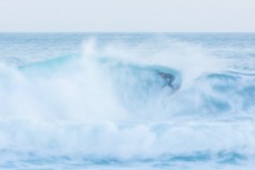 A surfer finds a nugget during a raw ground swell at St Kilda, Dunedin, New Zealand.