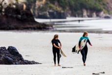Shani Ayson (left) and Britt Kindred return from a surf in waves created by ex-cyclone Gita at Aramoana, Dunedin, New Zealand.