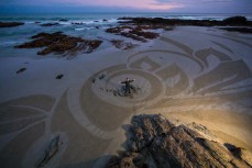 San Francisco artist Ian Ross creates an ephemeral piece of art from the low tide sand on the beach at Brighton, Dunedin, New Zealand. 