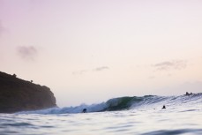 A surfer gets wave of the day on sunset at Indies, Raglan, Waikato, New Zealand.