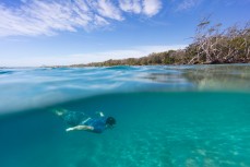 Blair Hughson soaking in the suns rays in the crystal clear waters of the Tweed River near Coolangatta on the Gold Coast, Queensland, Australia.