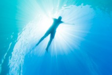 Blair Hughson soaking in the suns rays in the crystal clear waters of the Tweed River near Coolangatta on the Gold Coast, Queensland, Australia.