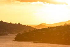 Winter sun rising directly over the Otago Harbour, Dunedin, New Zealand. 