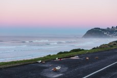 Dawn reveals small fun winter waves and discarded packaging at St Kilda, Dunedin, New Zealand. 