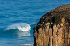 Waves break off a cliff headland during a large winter swell at St Clair, Dunedin, New Zealand. 