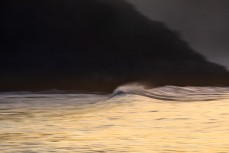 Evening light illuminates a fast dropping swell on the north coast, Dunedin, New Zealand.