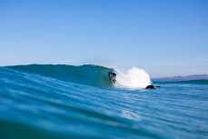 A surfer gets barreled in clean glassy waves at Blackhead, Dunedin, New Zealand.