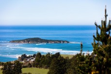 Late winter swell wraps around Moturata Island near Taieri Mouth, Dunedin, New Zealand.