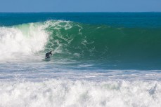 A surfer buries the rail in the Valley at Raglan, Waikato, New Zealand.