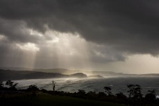 Headlands illuminated through the storm, Catlins, New Zealand.