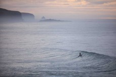 A surfer chases a lazy spring swell at St Clair, Dunedin, New Zealand.