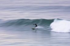 A surfer lines up a section in a spring swell at St Clair, Dunedin, New Zealand.