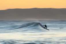 A surfer slides into a wave in the afternoon light at Blackhead, Dunedin, New Zealand.
Credit: www.boxoflight.com/Derek Morrison