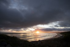 Sunset as summer waves roll in at Blackhead, Dunedin, New Zealand.
