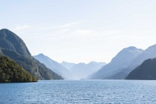Mountain ridges plunge into Dusky Sound during a Heritage Expeditions voyage to Dusky Sound in Fiordland, New Zealand.