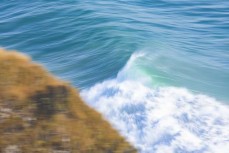 A large wave pushes along  a cliff near Dunedin, New Zealand.