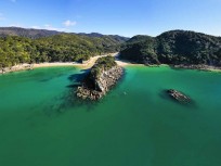 Paddleboarders explore Abel Tasman National Park on a stunning day on the water, Tasman, New Zealand.
