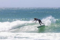 Jaya Reardon on rail during a warm summery afternoon in fun waves at Aramoana, Dunedin, New Zealand.