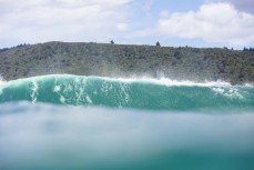 A large swell hits a point break near Dunedin, New Zealand.